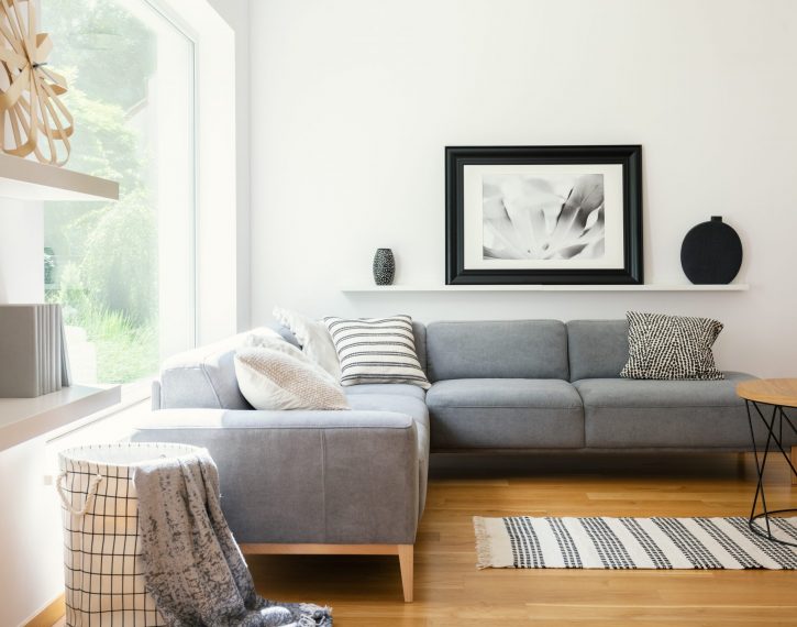 Black and white textiles and decorations in a classic scandinavian style living room interior with wooden furniture and natural sunlight
